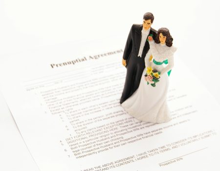 Groom and Bride figurines on prenup agreement